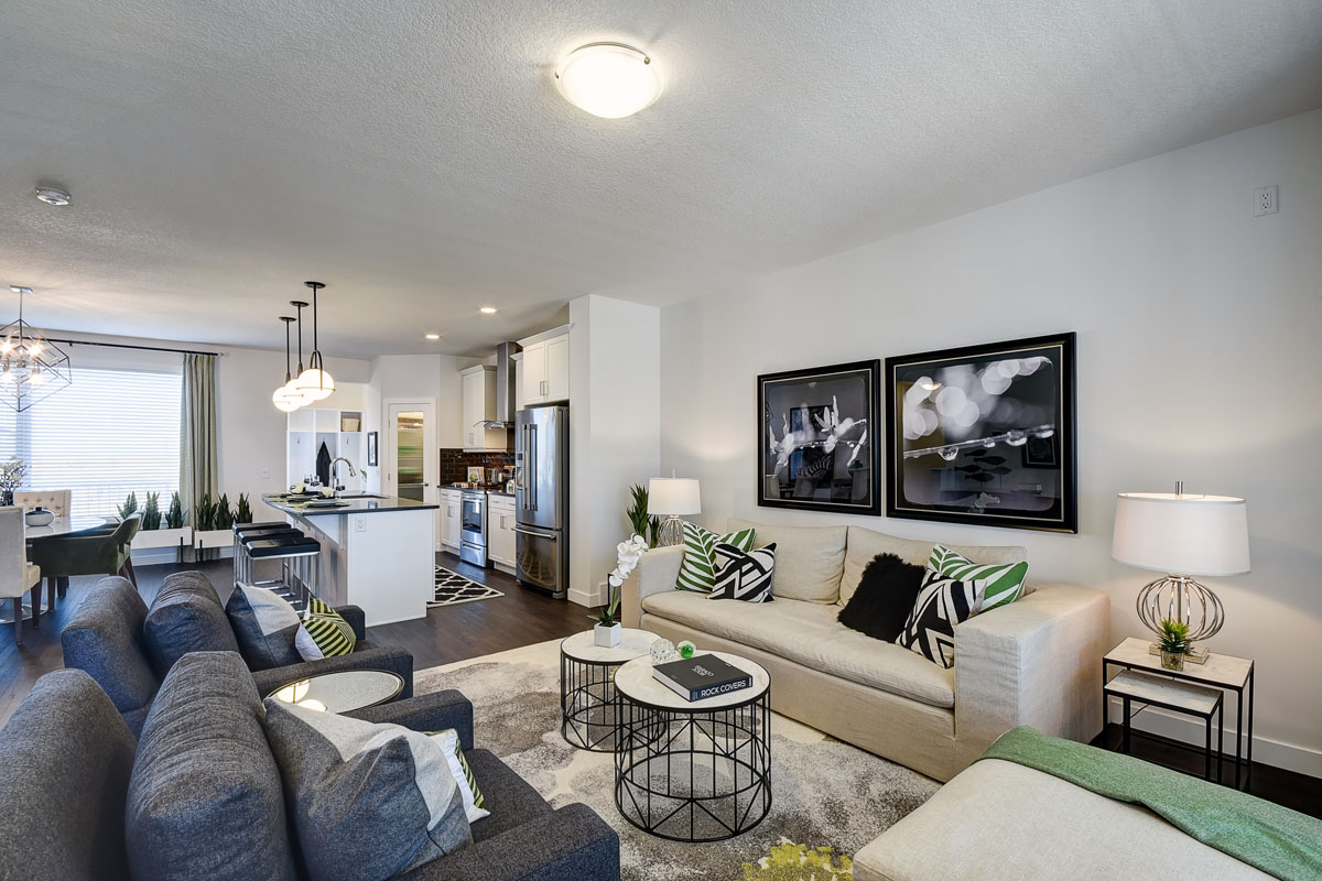 Living room area with 2 blue chairs and a beige love seat in the Banbury II model home from Nuvista Homes.
