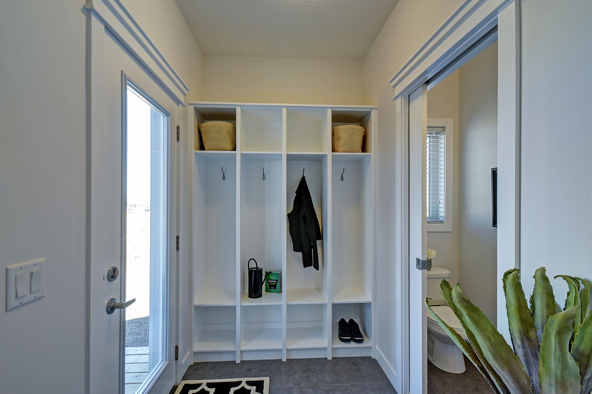 Mud room with shoes and a jacketing hanging up and baskets on top. In the Banbury II model home from Nuvista Homes.