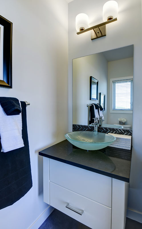 Powder room with navy blue towels hanging from the towel bar in the banbury II model home from Nuvista Homes.
