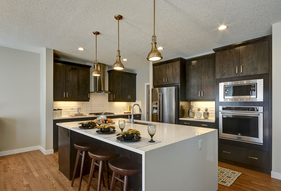Kitchen with modern style island and three wood barstool in the Bentley II model home.