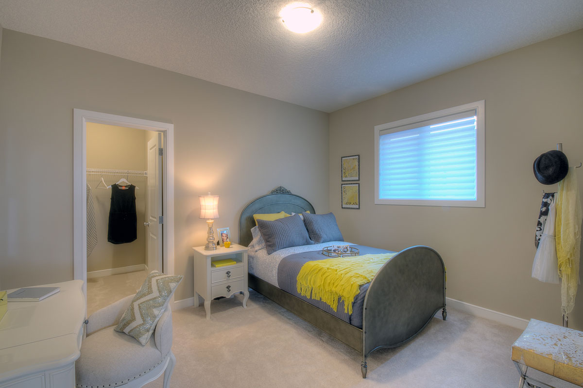Bedroom one with a twin bed and walk in closet in the Bentley II model home.