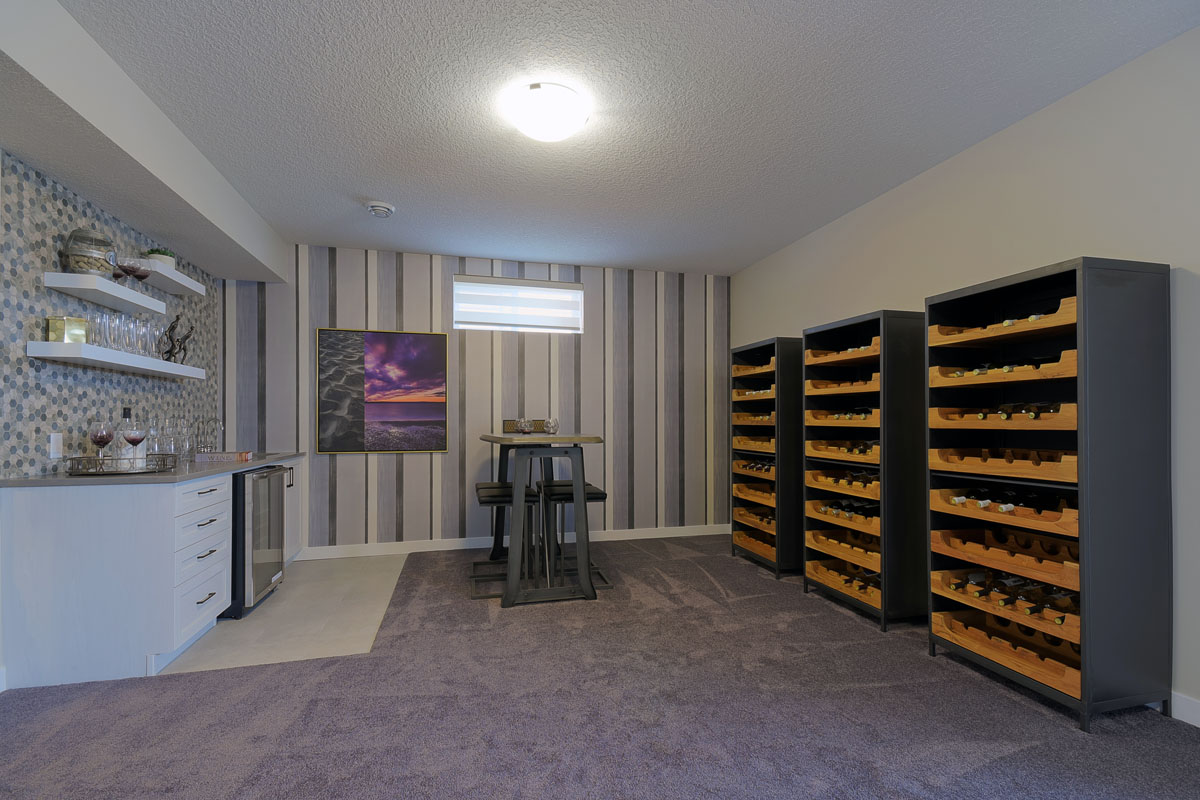 Basement with bar built with custom shelving and pin stripe accent wall in the Brentwood model home.