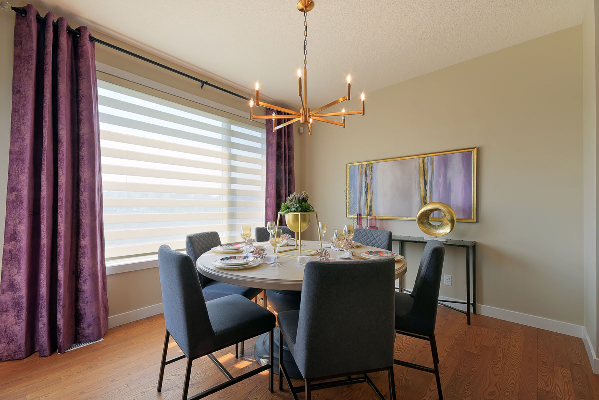 Dining room with round table and siz matching chairs with dark purple curtians in the Brentwood model home.