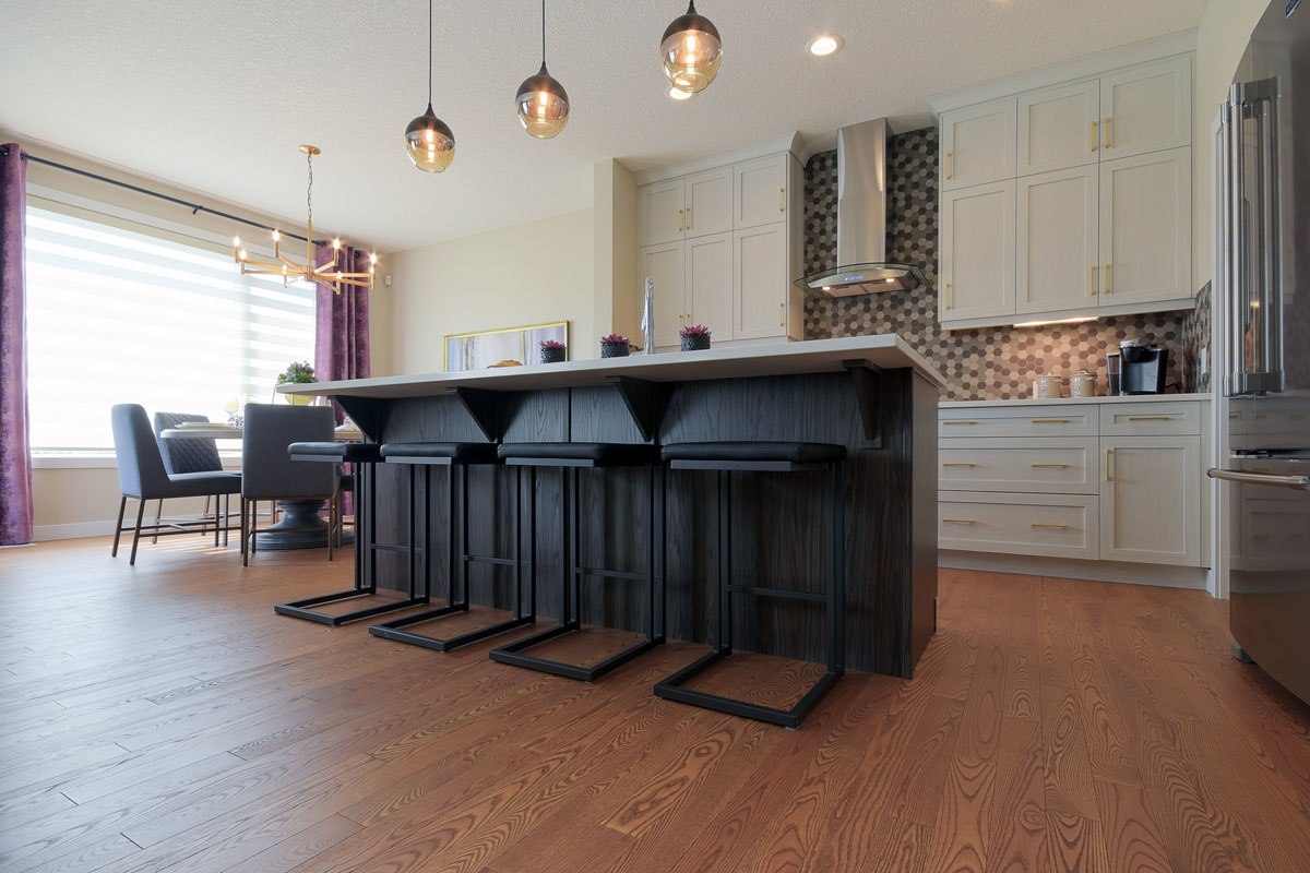 Kitchen behind the island with four ultra modern black bar stools in the Brentwood model home.
