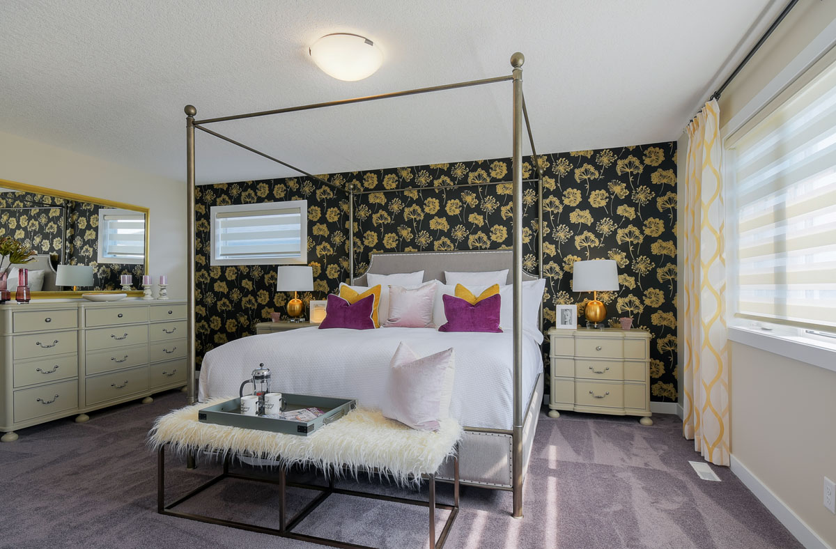 Master bedroom facing the king size bed and the yellow floral print wall and matching dresser and nightstands in the Brentwood model home.