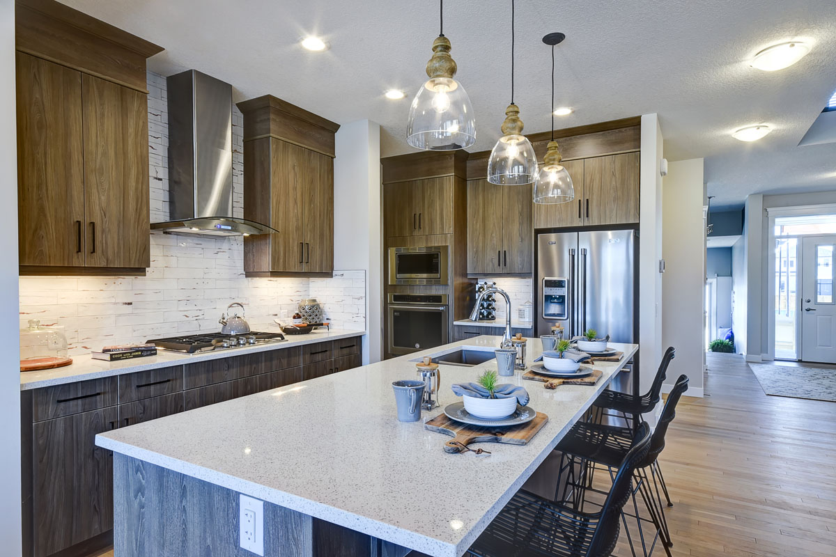 Kitchen in the Hamilton Wil model home with tan and grey modern style cupboards and white marble countertops