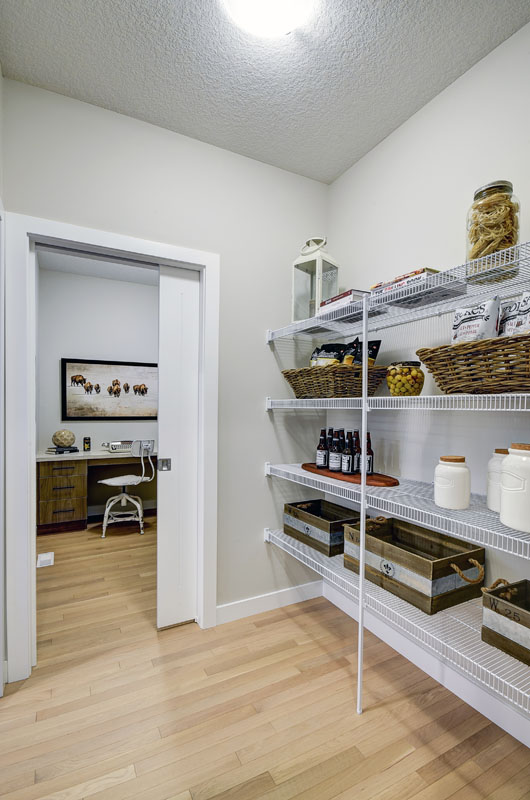 Pantry with white shelves and cooking supplies in the Hamilton Wil model home.