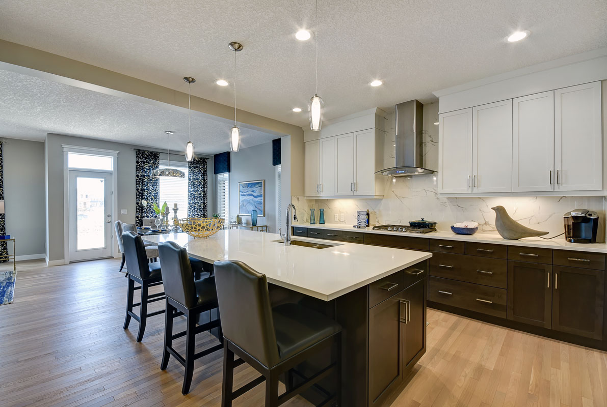 Kitchen facing the island with three chairs in the Inverness Red model home.