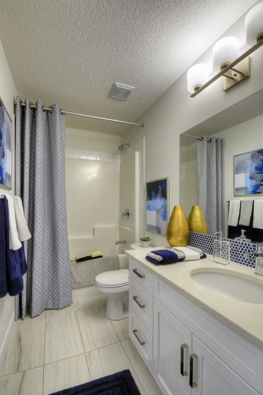 Bathroom in the Kingsley Cre model home with white tile flooring and white vanity.
