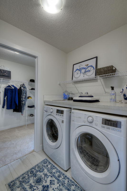 Laundry room with LG washer and dryer next to white and blue rug in the Kingsley Cre model home.