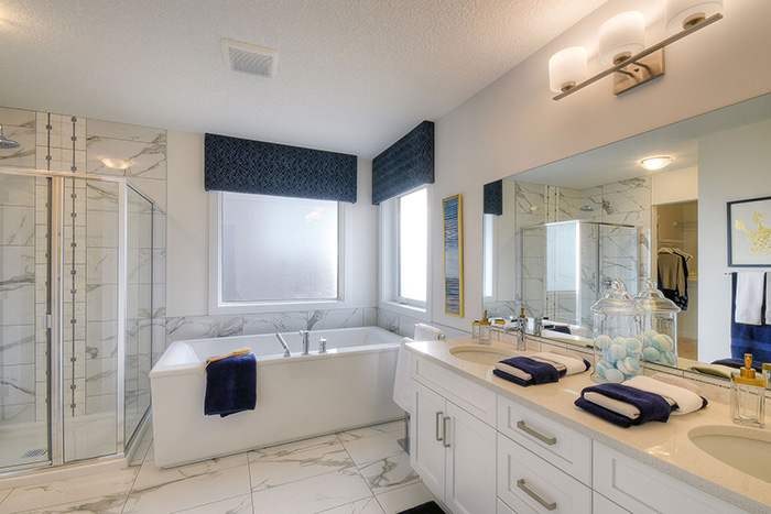 Master ensuite with white cabinets and white marble flooring in the Kingsley Cre model home.