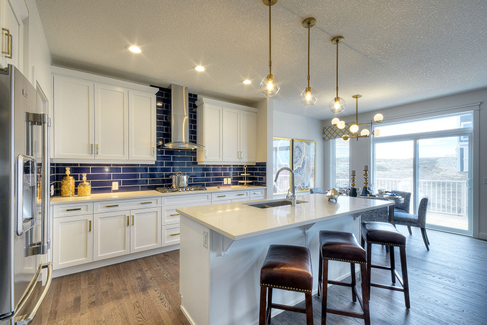 Kitchen with blue subway tile back splash and white cabinets in the Kingsley Cre model home.