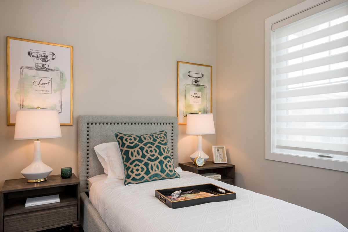 Bedroom two in the Kingston model home with twinbed and two wood nightstands.