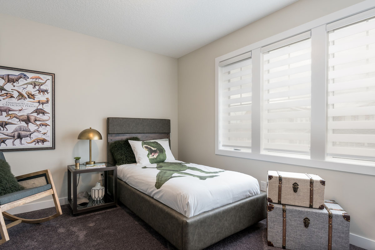 Bedroom one in the Kingston model home with twin bed and modern style lugage.