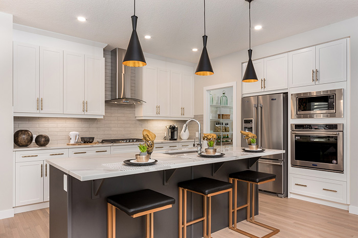 Kitchen with three modern barstools and stainless steel appliances in the Kingston model home.