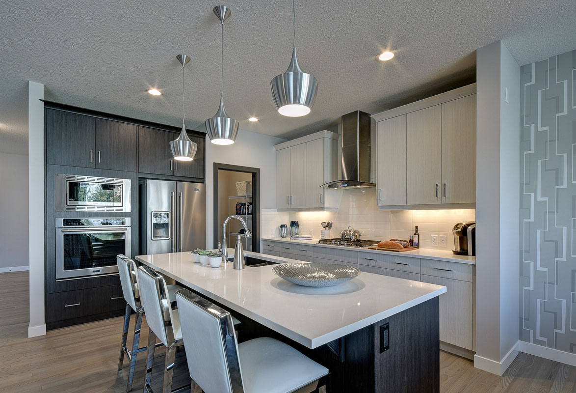 Kitchen with dark wood color cabinets and a large white marble island in the Kirkwood model home.