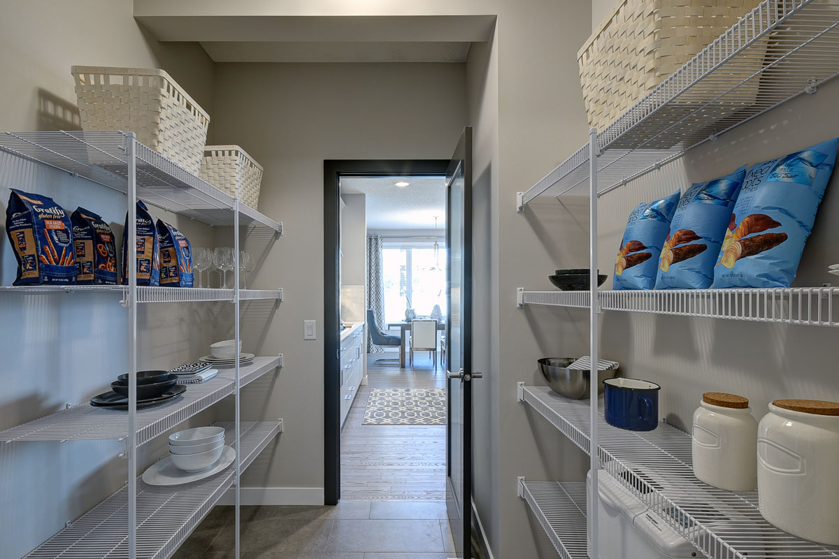 Pantry with white wire shelves holding cooking supplies and food in the Kirkwood model home.