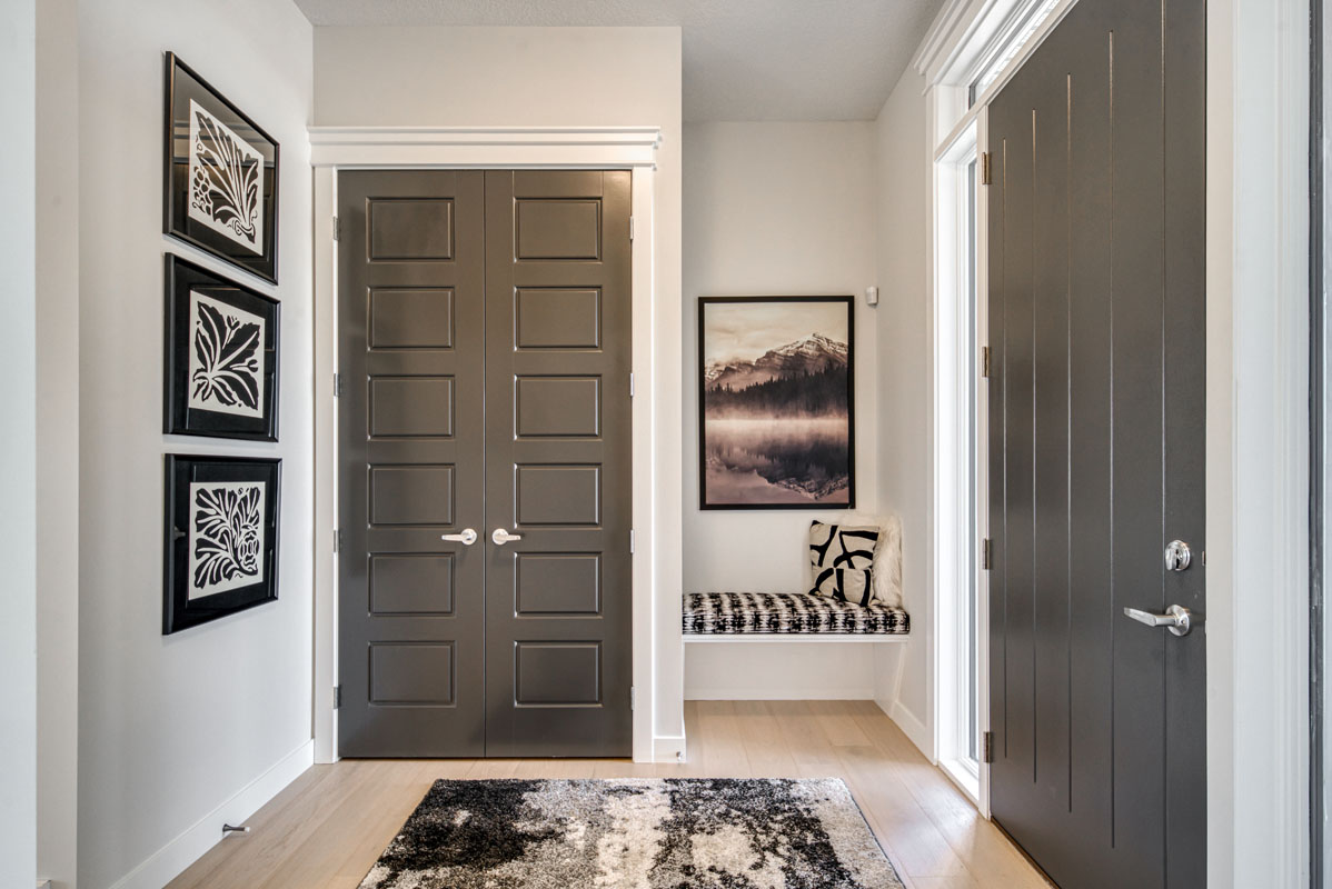 Main foyer with grey closet doors and small white bench in the Lakeview model home.