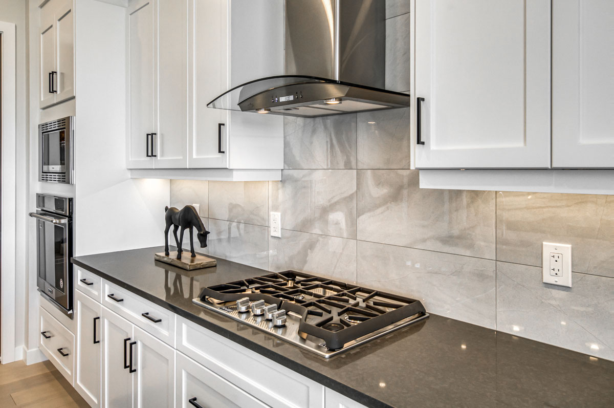 Stove top and grey granite countertops in the Lakeview model home.