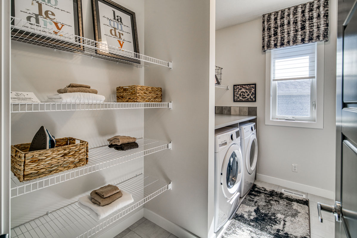 Laundry room with white shelving and two white LG washing machines in the Lakeview model home.