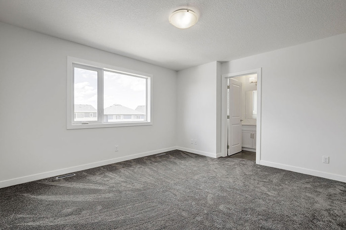 Master bedroom in the Maybank model home with grey carpet and white walls.