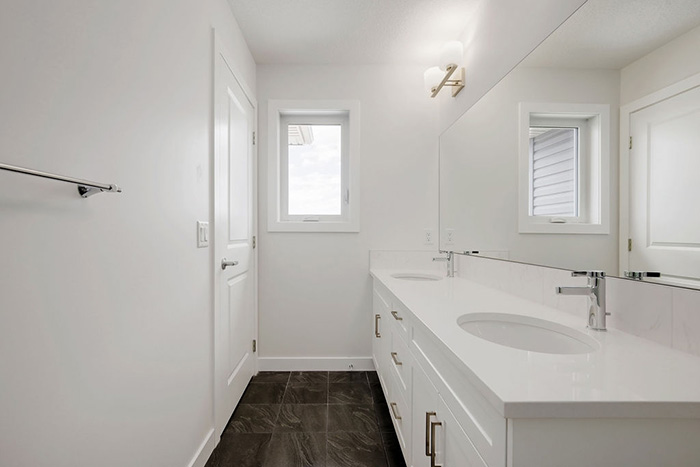 Bathroom in the Maybank model home with double white vanity and large mirror.
