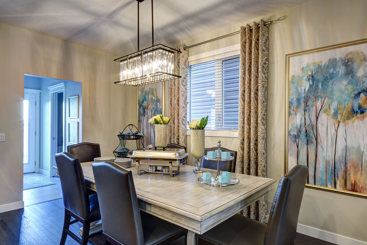 Dining room in the NuHaven II model home with chic over hanging chandelier and large table.