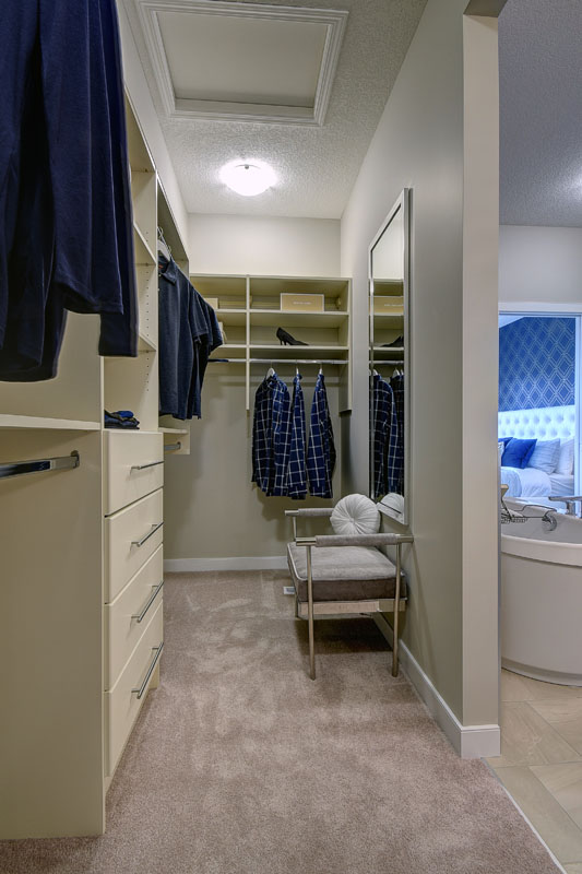 Walk in closet in the Cayenne model home with large dresser and built in shelves.