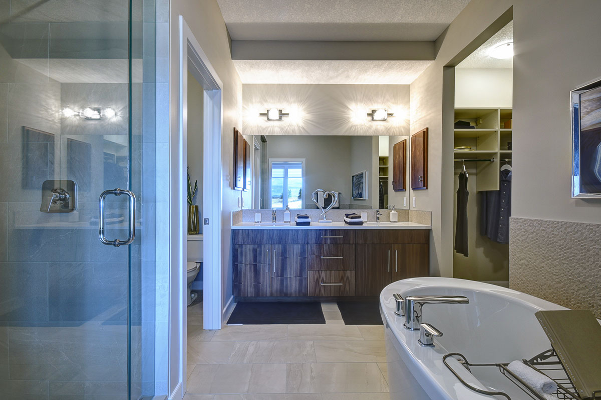 Ensuite bathroom with large open space and soaker tub across from shower and large double vanity in the Cayenne model home.