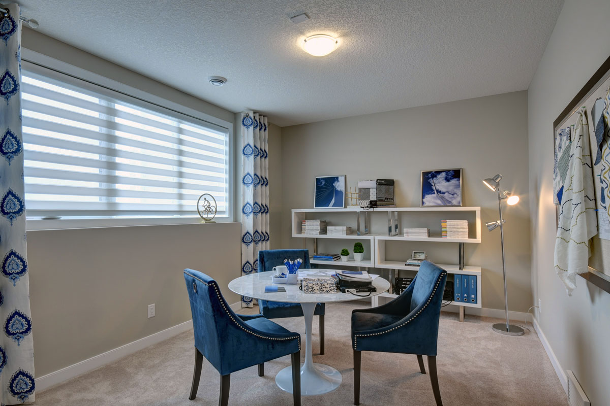 Office space with white retro table and three matching blue chairs in the Cayenne model home.