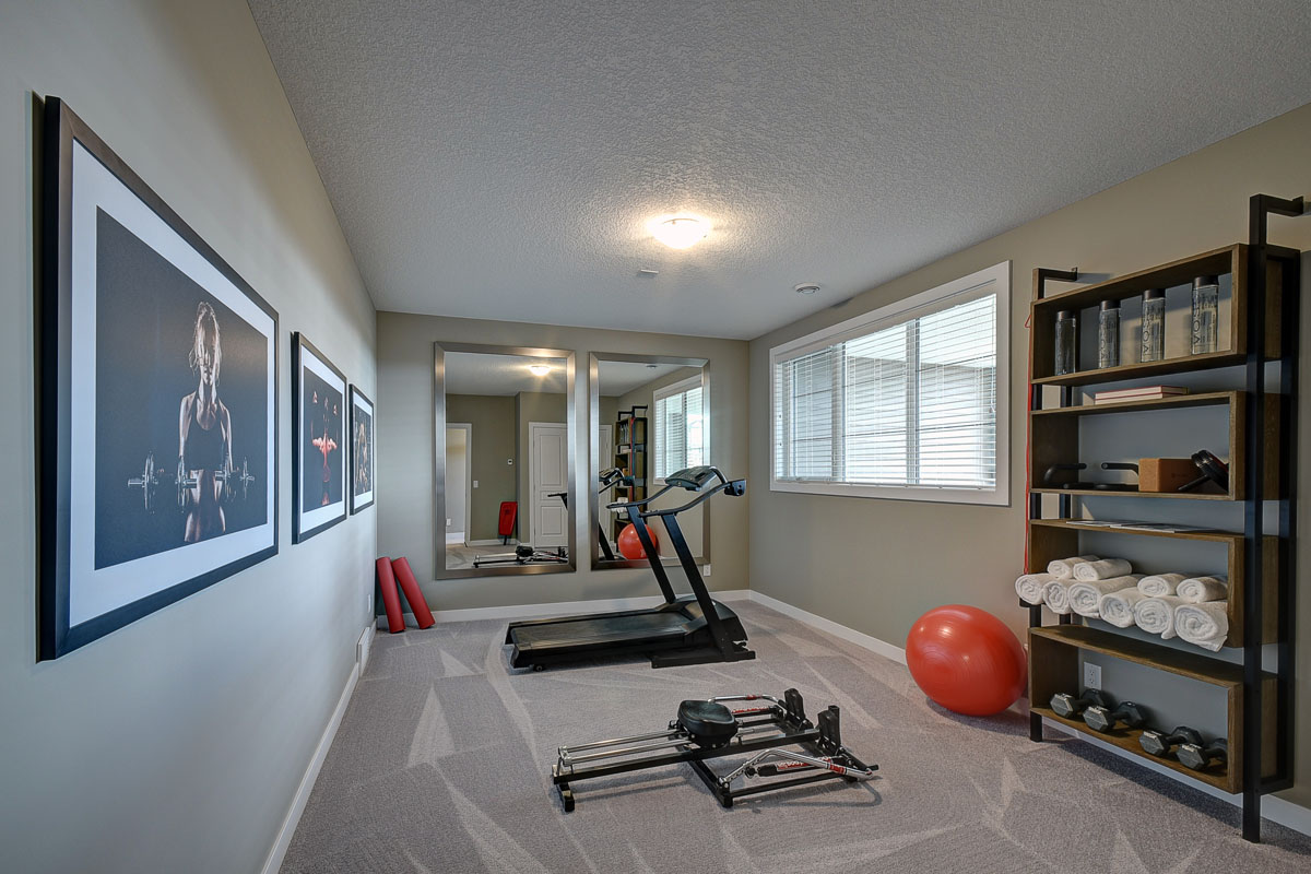 Gym in the Saffron model home with tredmill in front of large bay window in the Saffron model home.
