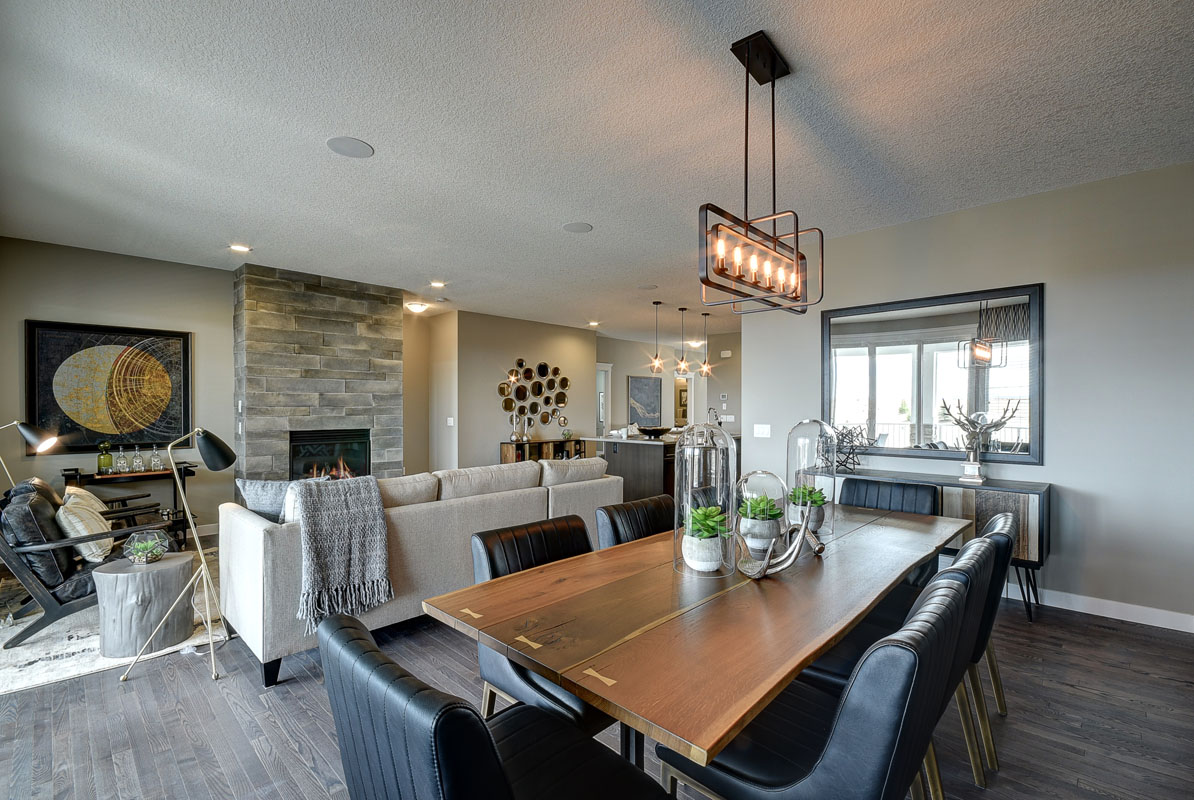 Dining room with large live edge wooden table and siz matching leather chairs in the Saffron model home.