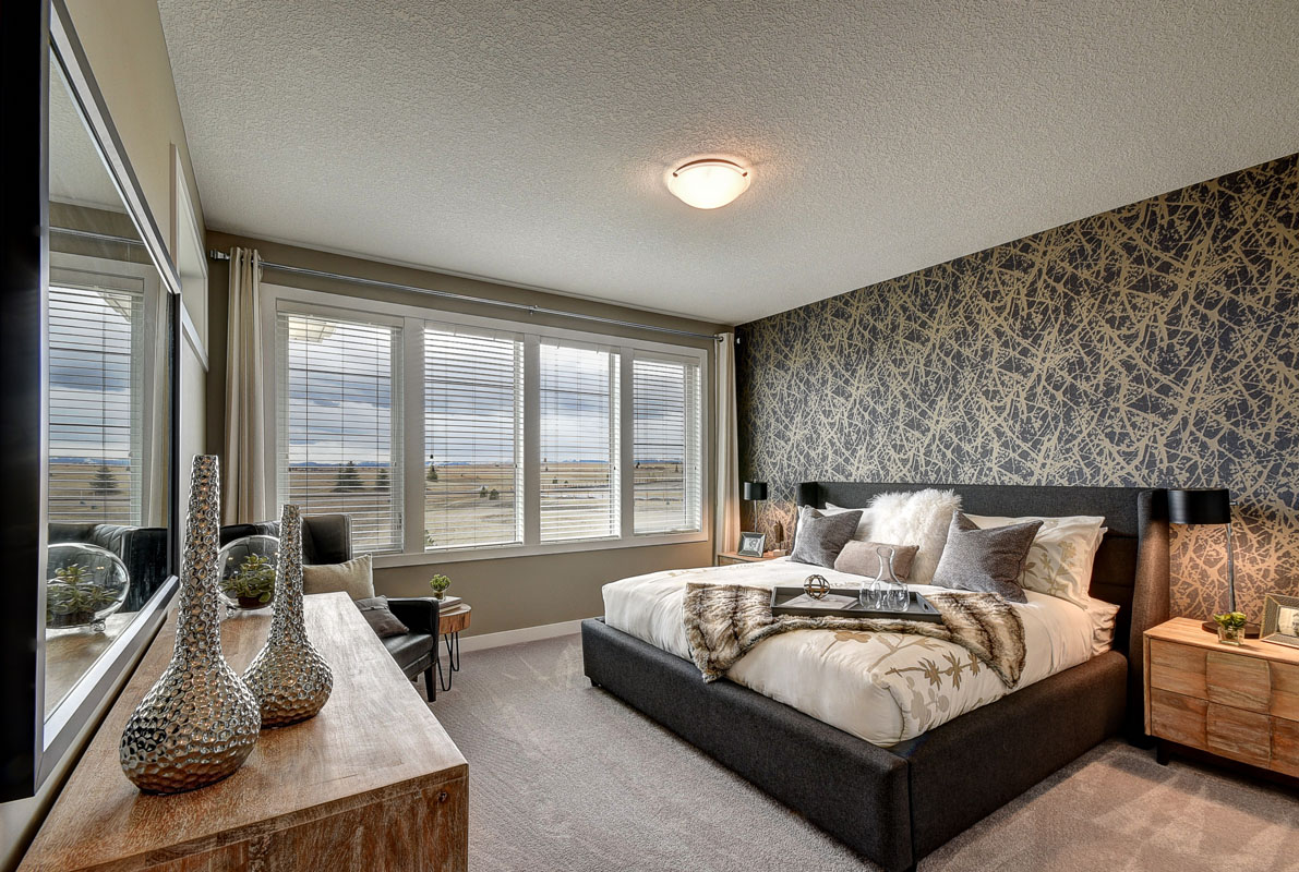 Large master bedroom with king size bed next to large four pannel windows in the Saffron model home.