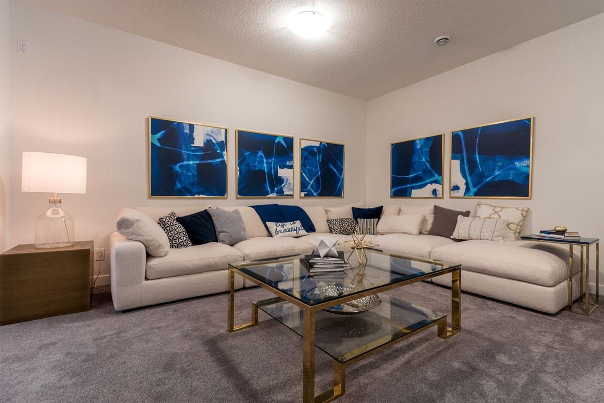 Basement area with large white sectional and glass coffee table in the Wilshire model home.