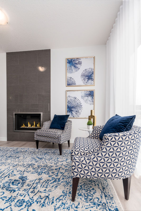 Close up of the two white and black diamoud print chairs and white and blue rug of the Wilshire model home.